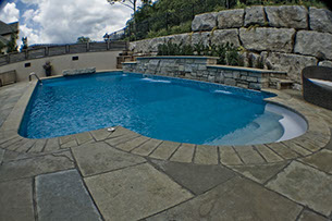 Blue Crystal Clear Swimming Pool with Rock Waterfall, Beautiful Backyard