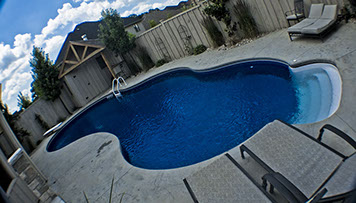 Blue Crystal Clear Swimming Pool with Rock Waterfall, Beautiful Backyard