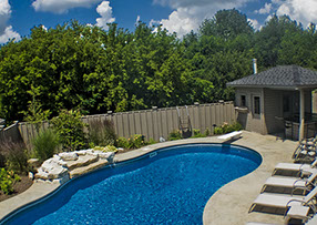 Blue Crystal Clear Swimming Pool with Rock Waterfall, Beautiful Backyard