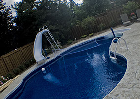 Blue Crystal Clear Swimming Pool with Rock Waterfall, Beautiful Backyard