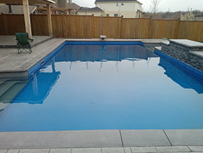 Blue Crystal Clear Swimming Pool with Rock Waterfall, Beautiful Backyard