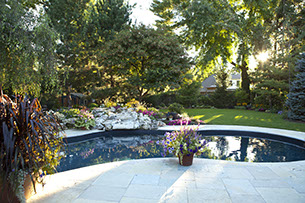 Blue Crystal Clear Swimming Pool with Rock Waterfall, Beautiful Backyard